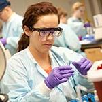 Female working with chemicals in a chemistry lab.